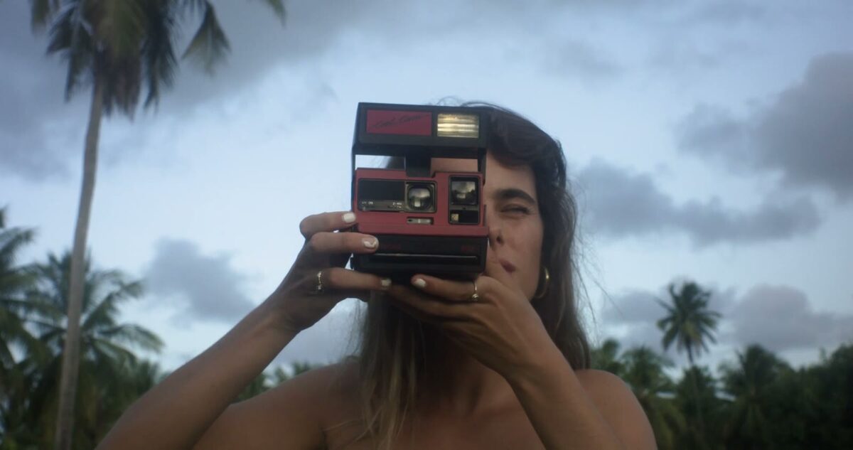 A traveller holding a polaroid camera